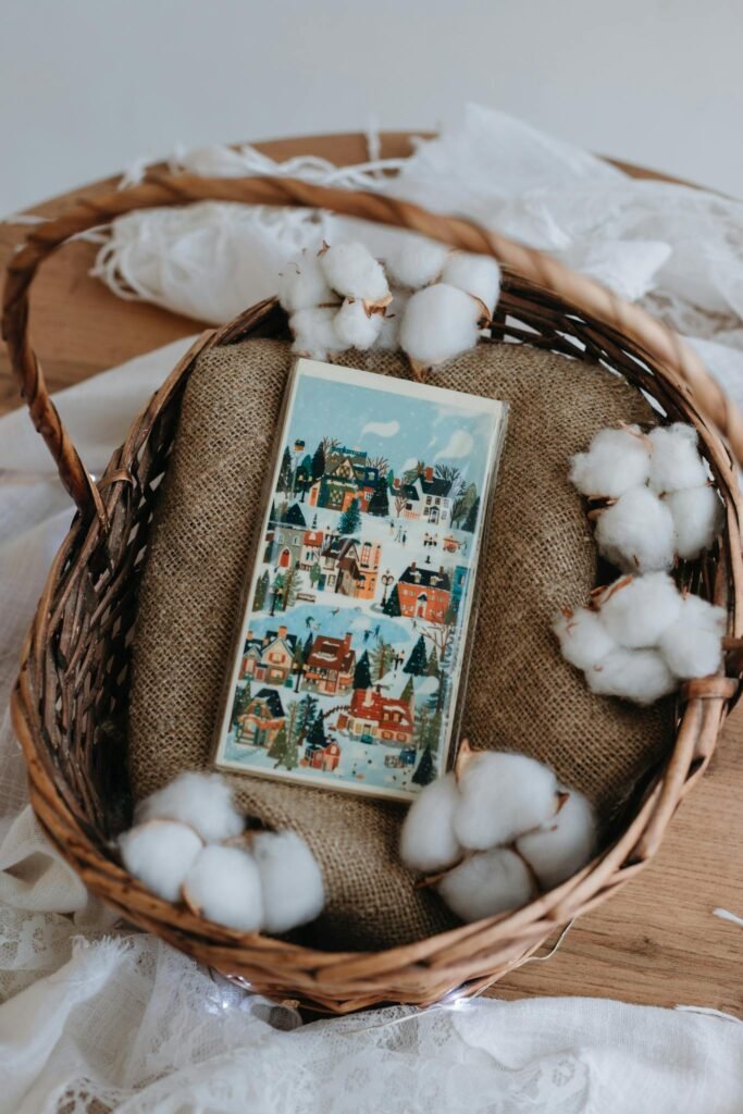 A charming rustic basket filled with a handmade card and cotton decorations, perfect for Christmas.