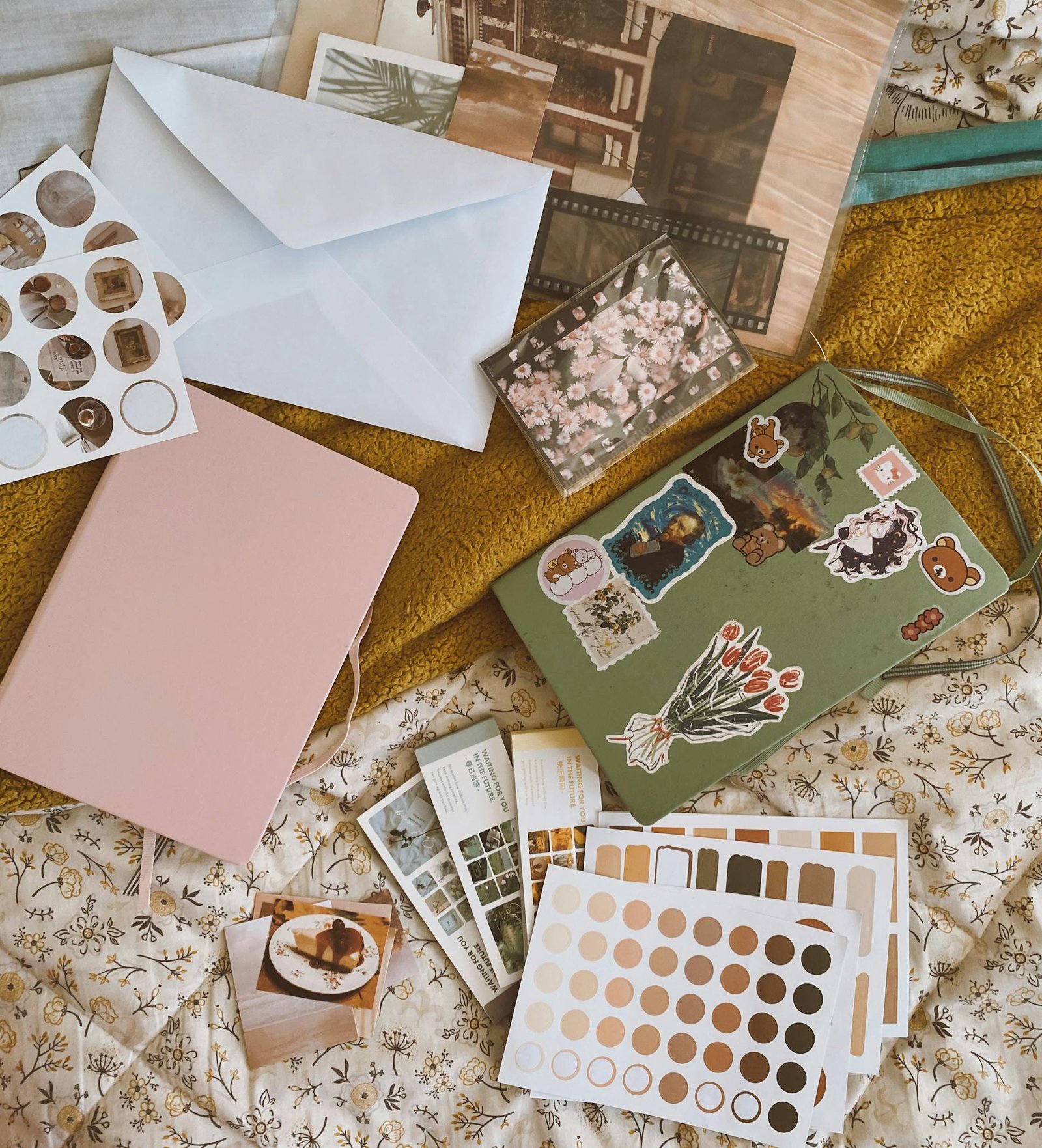 Aesthetic arrangement of notebooks, stickers, and envelopes in a cozy flat lay.